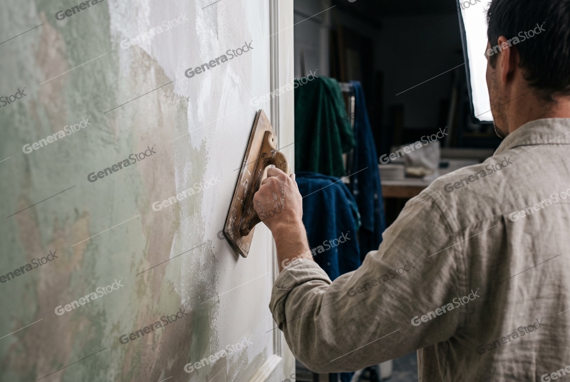 Craftsman applying Venetian plaster to a textured interior wall