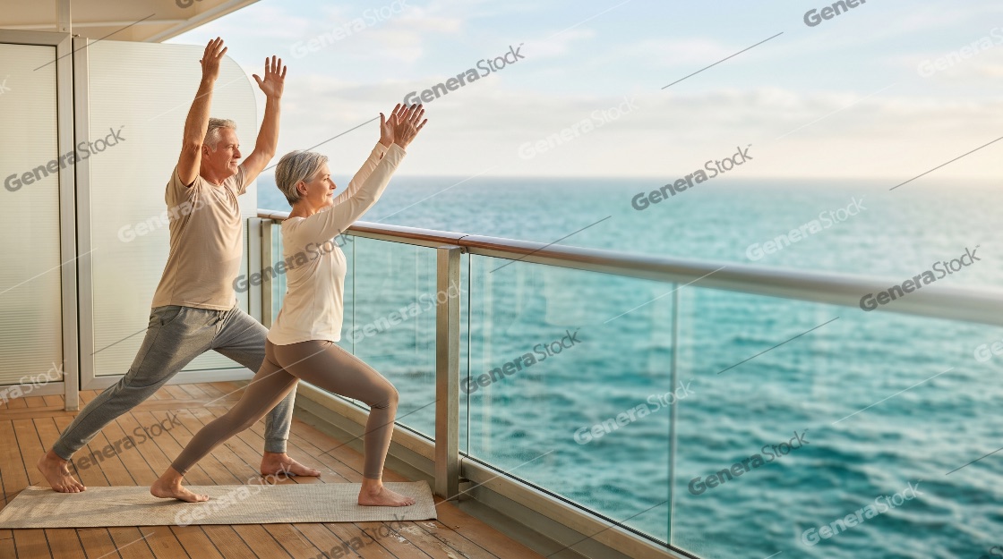 Active senior couple practicing yoga and stretching on a luxury cruise ship balcony with a beautiful ocean view