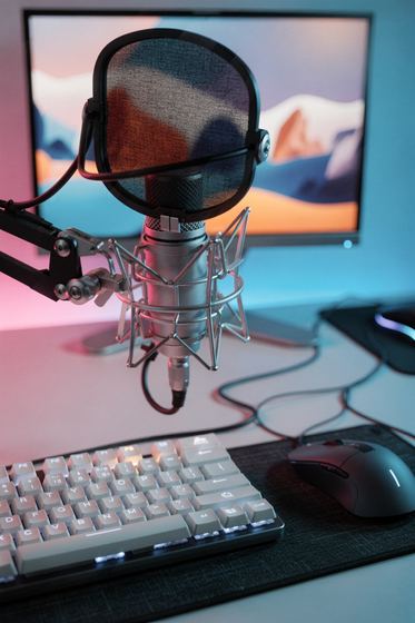 condenser mic on a boom arm, mechanical keyboard, pink and teal light