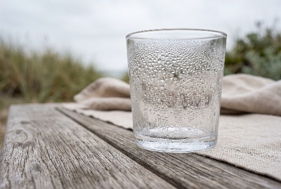 empty, cold, drinking, glass, covered, with, condensation, water, dro, close-up, shot, clear, tiny, droplets, from, the, rests, natural, linen, cloth, weathered, wooden, table, set, outdoors, softly, blurred, background, coastal, vegetation, and, light, sky, image, evokes, concepts, freshness, hydration, purity, quiet, relaxation, droplet, drinkware, tumbler, transparent, wet, liquid, refreshment, wood, rustic, outdoor, nature, beach, napkin, macro, texture, surface, moisture, dew, chilled, cool, summer, pure, clean, object, nobody, soft, focus, calm, peaceful, minimalist, eco-friendly, beverage, backgrounds, textures