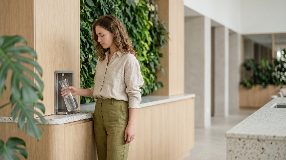 young, woman, filling, glass, carafe, from, water, dispenser, sustainable, modern, office, interior, with, vertical, garden, green, wall, hydration, healthy, lifestyle, eco-friendly, wellness, professional, workplace, environment, sustainability, drinking, fresh, clean, minimalist, architecture, design, plants, nature, indoor, business, casual, employee, corporate, kitchen, breakroom, refreshment, liquid, pouring, health, biophilic, biophilia, station, finance