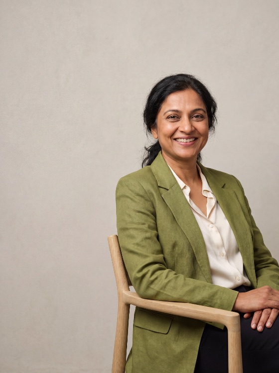 confident, and, smiling, middle-aged, indian, professional, woman, wearing, stylish, green, linen, blazer, white, blouse, sitting, wooden, chair, against, neutral, studio, background, for, corporate, portrai, business, portrait, mature, executive, leader, jacket, female, success, career, entrepreneur, management, diversity, inclusion, south, asian, ethnic, lifestyle, friendly, approachable, smart, casual, formal, headshot, looking, camera, one, person, adult, 40s, 50s, elegance, sophisticated, empowerment, businesswoman, modern, office, people