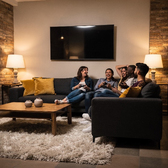 diverse, group, happy, young, friends, laughing, and, playing, vide, sit, grey, sofa, while, video, games, with, controllers, the, modern, living, room, has, brick, walls, warm, lamps, wooden, coffee, table, wall-mounted, gaming, fun, social, evening, night, home, couch, entertainment, lifestyle, togetherness, adults, indoor, cozy, interior, leisure, friendship, multi-ethnic, people, sitting, technology, competition, game, relaxation, apartment, house, wall, lamp, lighting, rug, joy, excitement, bonding, activity, hobby, play, gamer, console, weekend, interiors