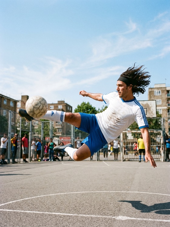 dynamic, shot, professional, soccer, player, performing, mid-air, volley, kick, urban, street, court, football, athlete, bicycle, jumping, pitch, asphalt, city, sports, action, energy, skill, man, long, hair, headband, jersey, shorts, cleats, ball, game, match, competition, outdoor, sunny, day, lifestyle, hobby, exercise, fitness, training, teamwork, community, neighborhood, goal, scoring, movement, agility, power, athletic