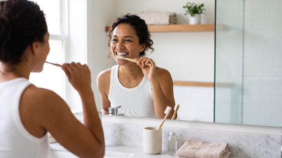smiling, young, woman, brushing, her, teeth, with, eco-friendly, bamb, brushes, bamboo, toothbrush, front, bathroom, mirror, the, bright, modern, space, features, marble, counters, and, white, tiles, she, wears, tank, top, focusing, morning, dental, hygiene, routine, clean, minimalist, environment, smile, healthy, sustainable, lifestyle, reflection, wellness, oral, care, cleaning, interior, daily, personal, beauty, health, adult, female, home, domestic, self-care, mouth, natural, organic, sink, faucet, plant, towel, skincare, fresh, grooming, wellbeing, photography, people