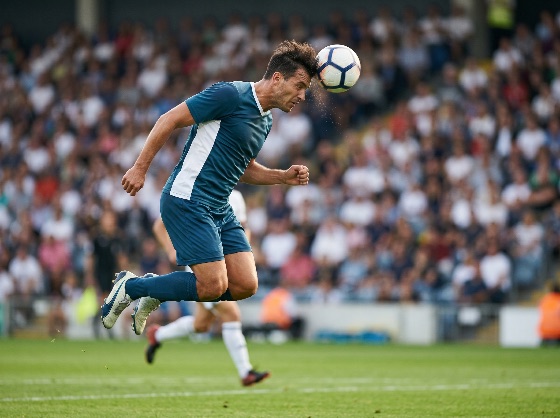 professional, soccer, player, blue, uniform, jumping, head, the, ball, during, competitive, match, crowded, stadium, football, header, jump, action, athlete, sport, competition, jersey, heading, game, crowd, field, pitch, athletic, movement, power, concentration, skill, male, outdoors, daytime, goal, performance, teamwork, activity, fitness, energy, strike, contact, focus, intensity, dynamic, lifestyle, hobby, recreation, league, tournament, championship, score, winning, challenge, effort, training, sports