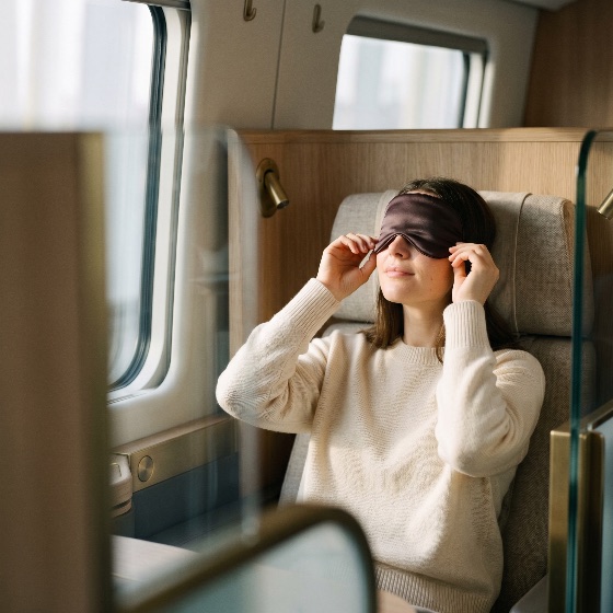 young, woman, passenger, wearing, silk, eye, mask, for, sleep, while, traveling, luxury, first-class, train, cabin, travel, first, class, relaxation, comfort, transport, business, journey, resting, interior, railway, lifestyle, vacation, trip, commuter, window, modern, premium, elegant, cozy, peaceful, transit, sleeping, accessories, places
