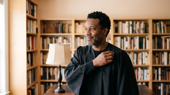 portrait, confident, african, american, man, wearing, black, academic, judicial, robe, library, filled, with, books, professor, judge, gown, bookshelves, education, law, scholar, graduation, professional, intellectual, success, wisdom, mature, male, study, office, literature, knowledge, career, achievement, legal, university, college, teacher, educator, justice, authority, smiling, indoors, lifestyle, learning, research, history, philosophy, culture, diversity, inclusion
