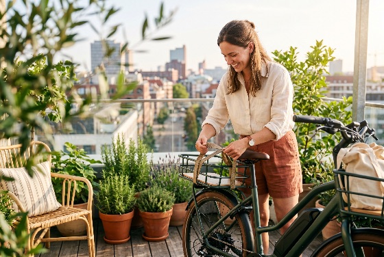 happy, young, woman, adjusting, strap, her, electric, bicycle, sunny, rooftop, terrace, with, city, skyline, background, bike, e-bike, urban, lifestyle, smiling, transportation, sustainability, eco-friendly, garden, plants, view, summer, commute, mobility, green, energy, leisure, outdoors, adult, female, casual, apartment, balcony, morning, travel, active, healthy, environment, modern, life, luggage, rack, preparation, wooden, deck, people