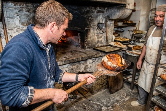 male, baker, removing, fresh, loaf, artisan, sourdough, bread, from, traditional, wood-fired, stone, oven, rustic, bakery, baking, peel, wooden, kitchen, food, handmade, professional, cook, chef, crusty, hot, fire, flour, craft, culinary, pastry, skill, occupation, interior, authentic, heritage, old-fashioned, gourmet, delicious, healthy, organic, yeast, dough, apron, drink