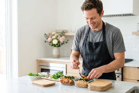 happy, young, man, apron, preparing, healthy, vegan, meal, prep, containers, with, sweet, potatoes, chickpeas, and, kale, bright, modern, kitchen, eating, cooking, vegetarian, nutrition, lifestyle, preparation, glass, potato, home, wellness, diet, organic, food, planning, adult, smiling, domestic, interior, sustainability, zero, waste, eco-friendly, lunch, dinner, fitness, health, culinary, chef, hobby, routine, organized, storage, fresh, ingredients, vegetables, plant-based, drink