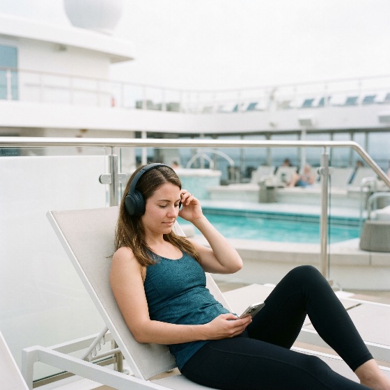 young, woman, athletic, wear, relaxing, sun, lounger, cruise, ship, deck, while, listening, music, with, headphones, and, using, her, smartphone, vacation, travel, relaxation, leisure, pool, lifestyle, tank, top, leggings, luxury, tourism, holiday, technology, mobile, phone, outdoors, summer, wellness, peaceful, serene, passenger, ocean, liner, resort, swimming, digital, nomad, connectivity, people