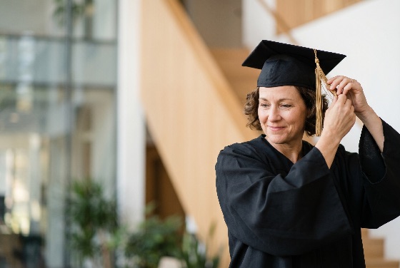 proud, mature, woman, graduation, gown, and, cap, adjusting, tassel, university, commencement, graduate, education, success, achievement, college, student, diploma, learning, adult, career, smiling, ceremony, academic, mortarboard, degree, lifelong, concept, professional, goal, accomplishment, middle-aged, female, indoor, background, blurred