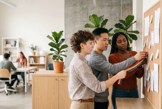diverse, team, young, professionals, pinning, rainbow, ribbon, corkboard, bright, modern, office, demonstrating, workplace, inclusion, and, pride, support, diversity, lgbtq, coworkers, collaboration, equality, community, multiethnic, asian, black, non-binary, interior, plants, notes, holding, working, together, corporate, culture, human, rights, social, justice, tolerance, togetherness, friendship, professional, business, startup, creative, lifestyle, cooperation, unity, lgbt, symbol, activism, awareness, belonging, empowerment, finance
